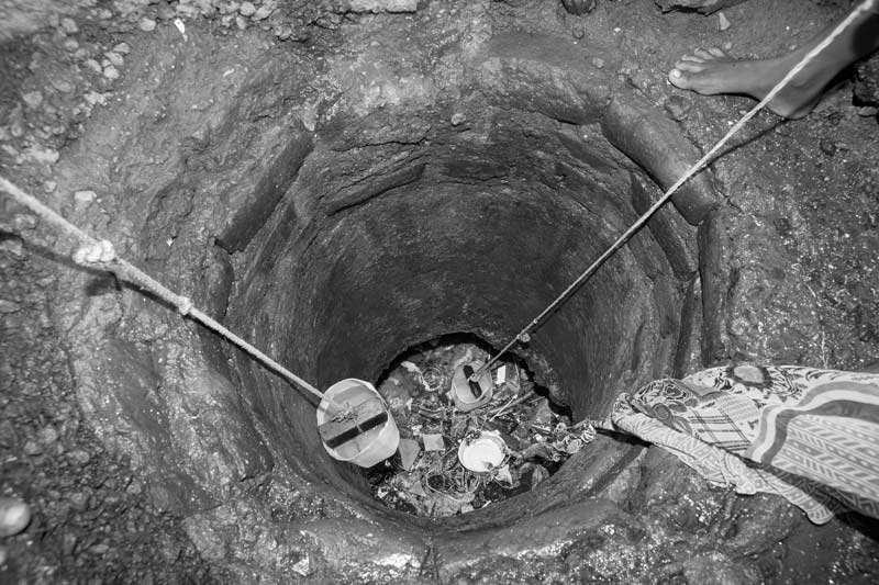 Human Right to Water in Mumbai - Drawing of water from a nearly dried and filthy hole near a Pardhi locality